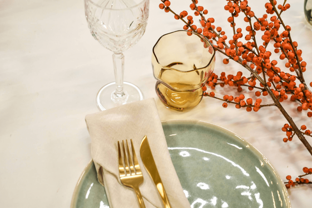 Borddækning med sage stentøj i mint, guldbestik og limfjord amber vandglas